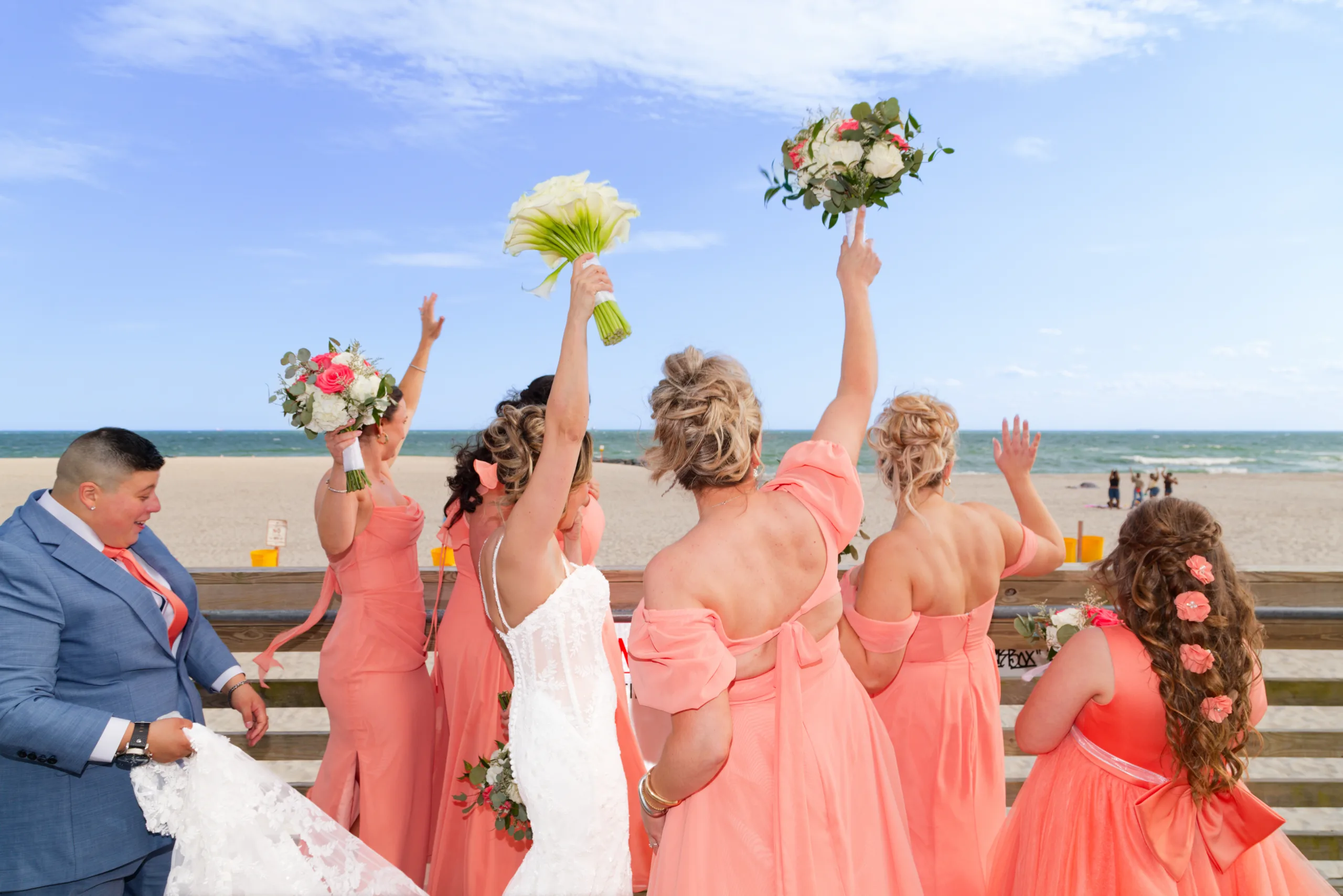 Bridesmaids raising their bouquets
